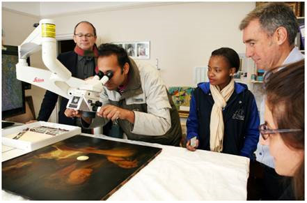 Click the image for a view of: Iziko team examining the Leica microscope prior to purchase with Teched, photograph by C. Beyer.